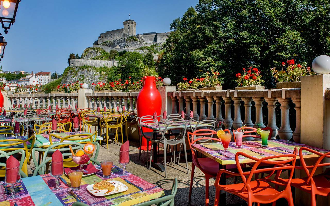 Colorful tables on the terrace in the sun, brasserie lourdes, Hotel La Solitude.
