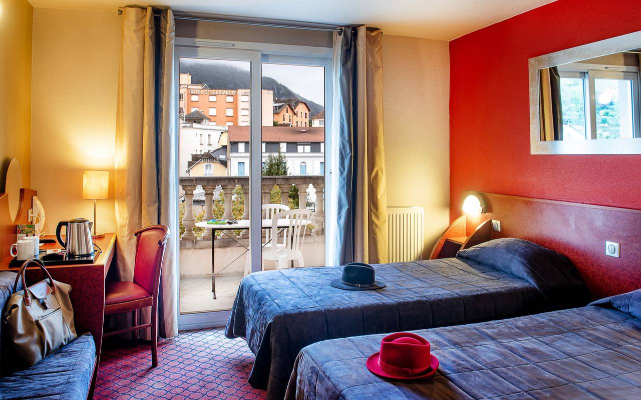 Room with two beds for 1 person with table on the balcony, hotel pyrenees– Hotel la Solitude