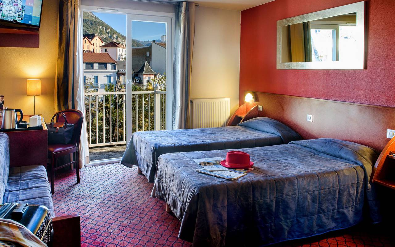 Chambre spacieuse avec balcon et bureau ainsi que deux lits simples, hotel lourdes avec piscine, Hôtel La Solitude.